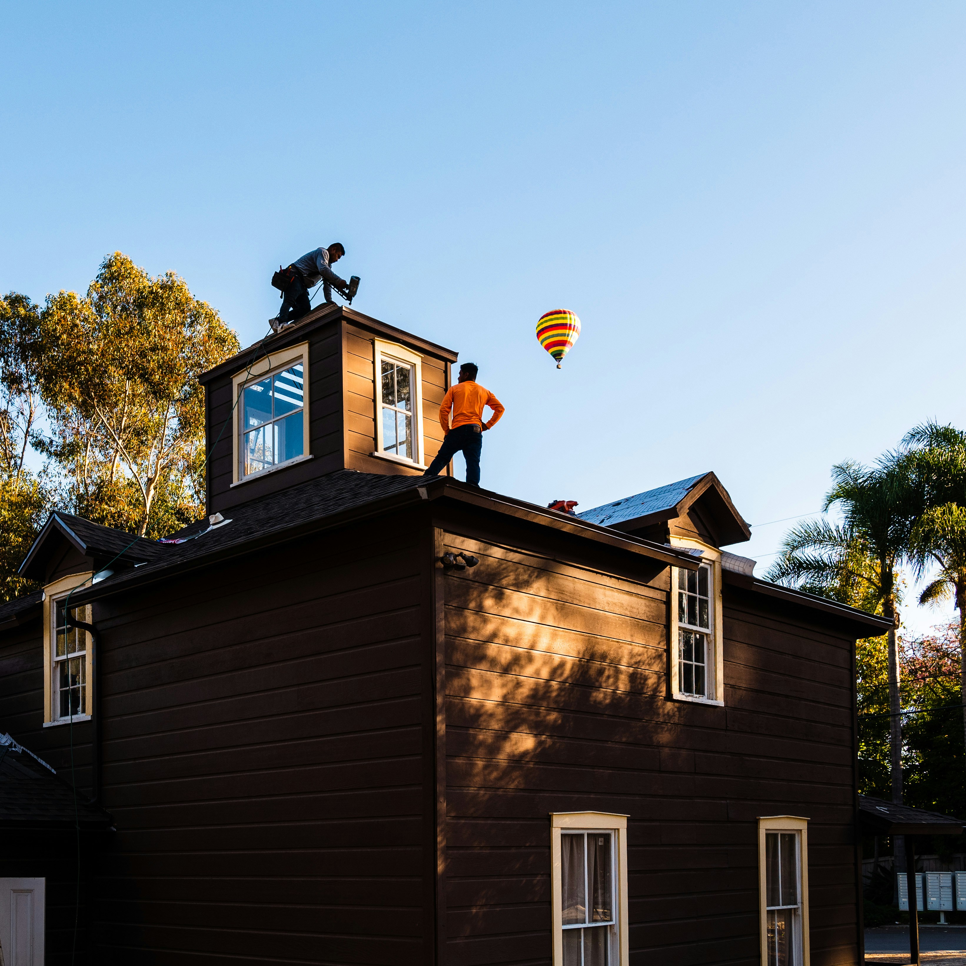 A man standing on top of a brown building