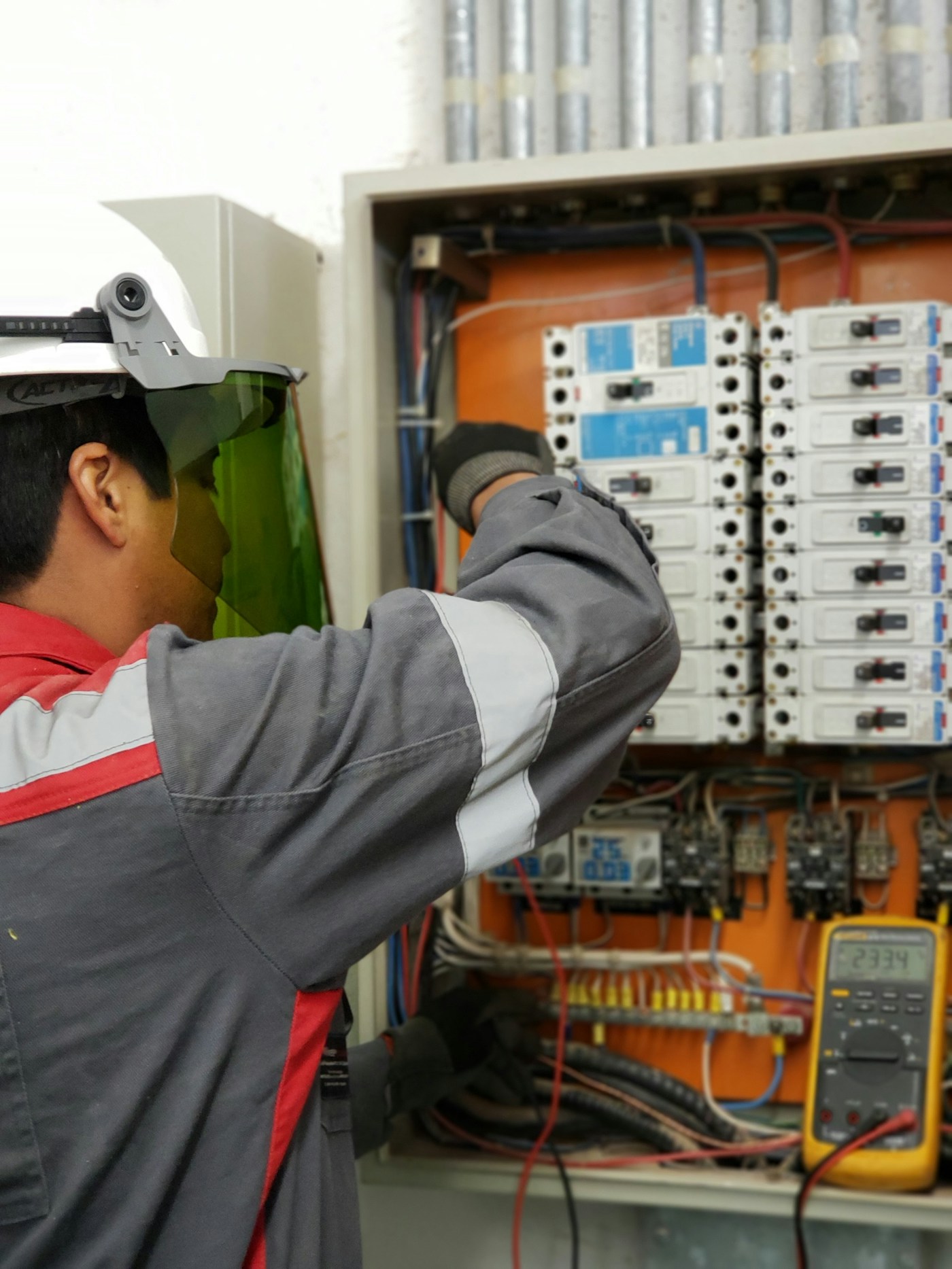 Electrician wiring breakers inside an open electrical panel