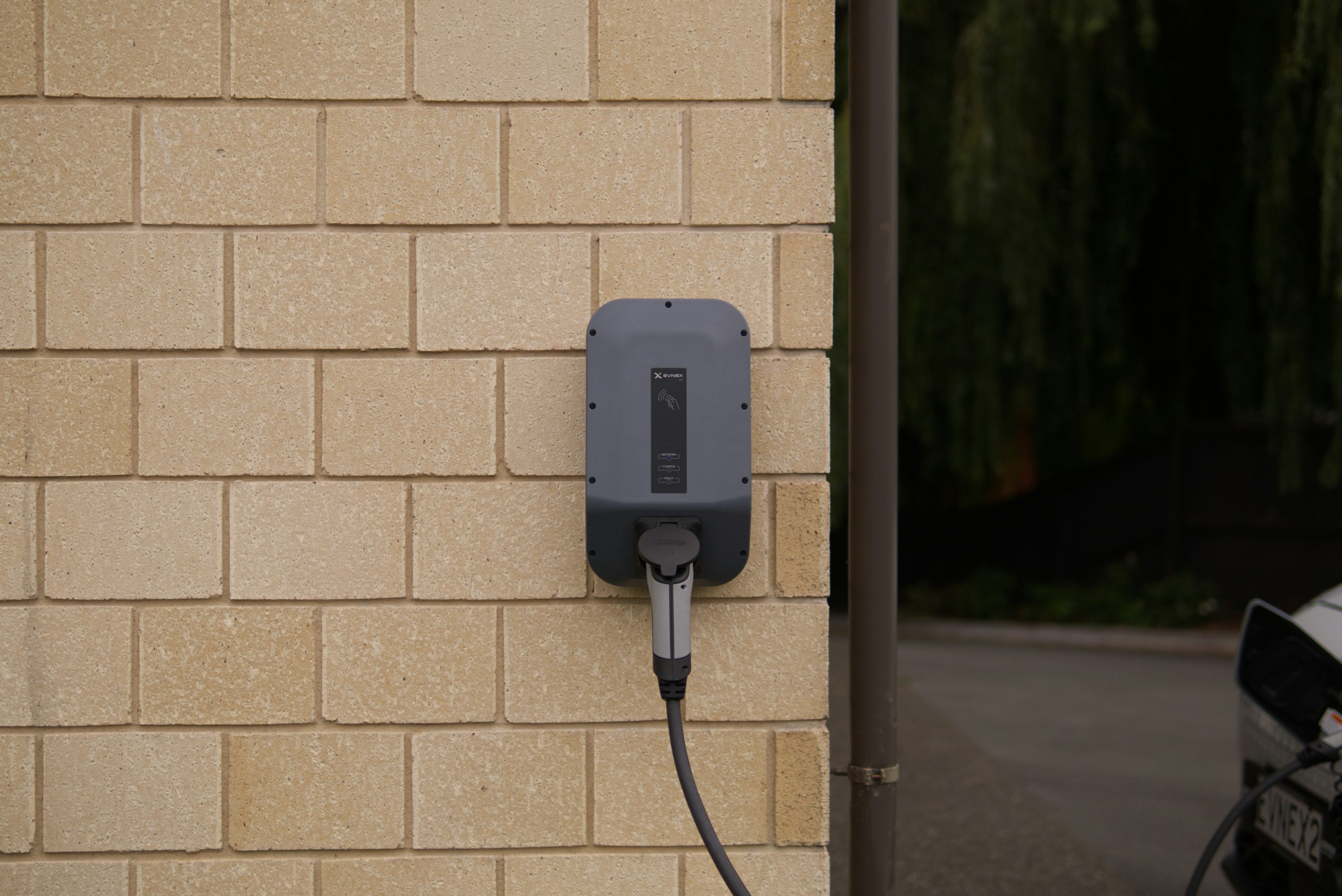 After: wall-mounted EV charger installed in the garage with the cable plugged in