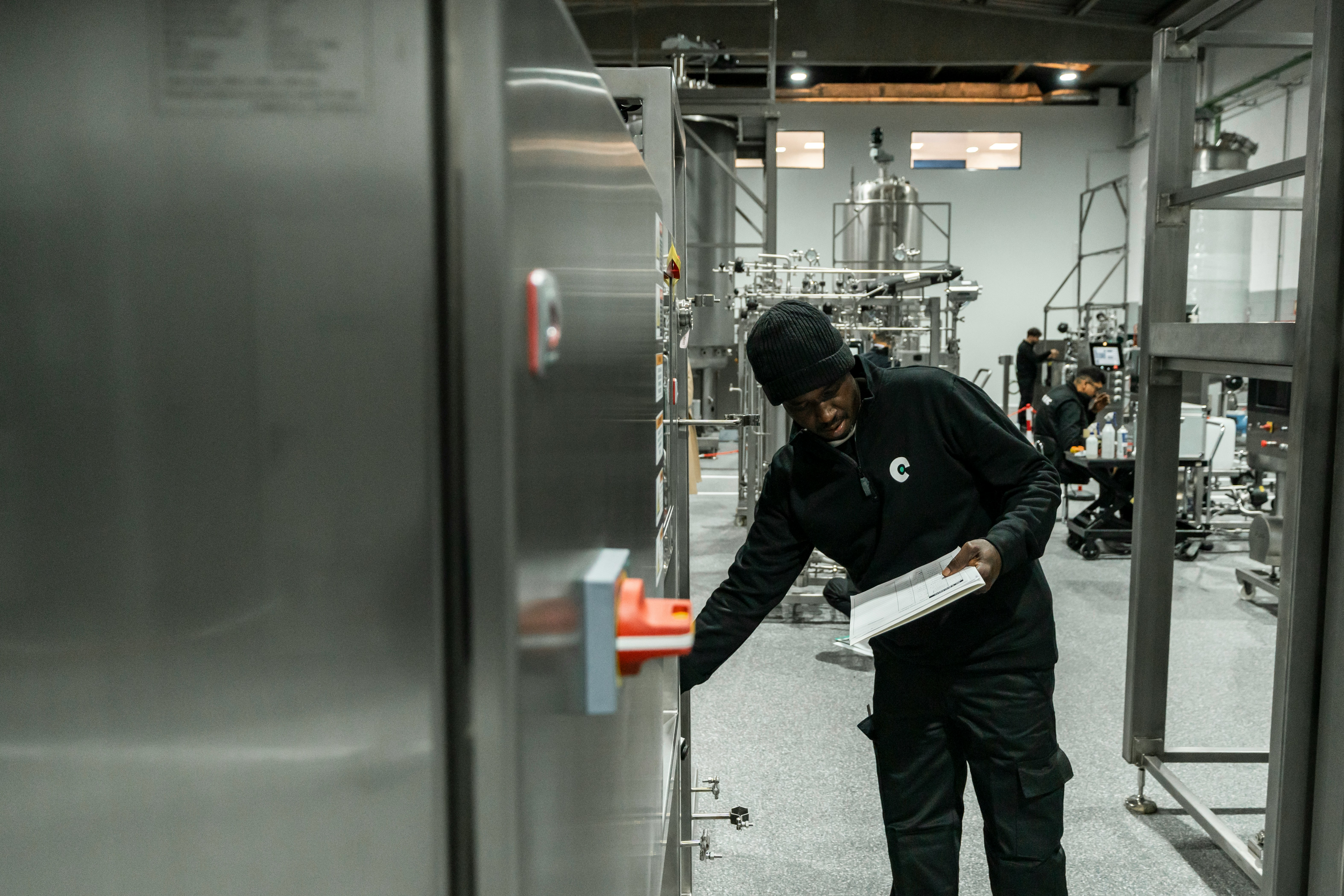 A man inspects equipment in a modern factory.