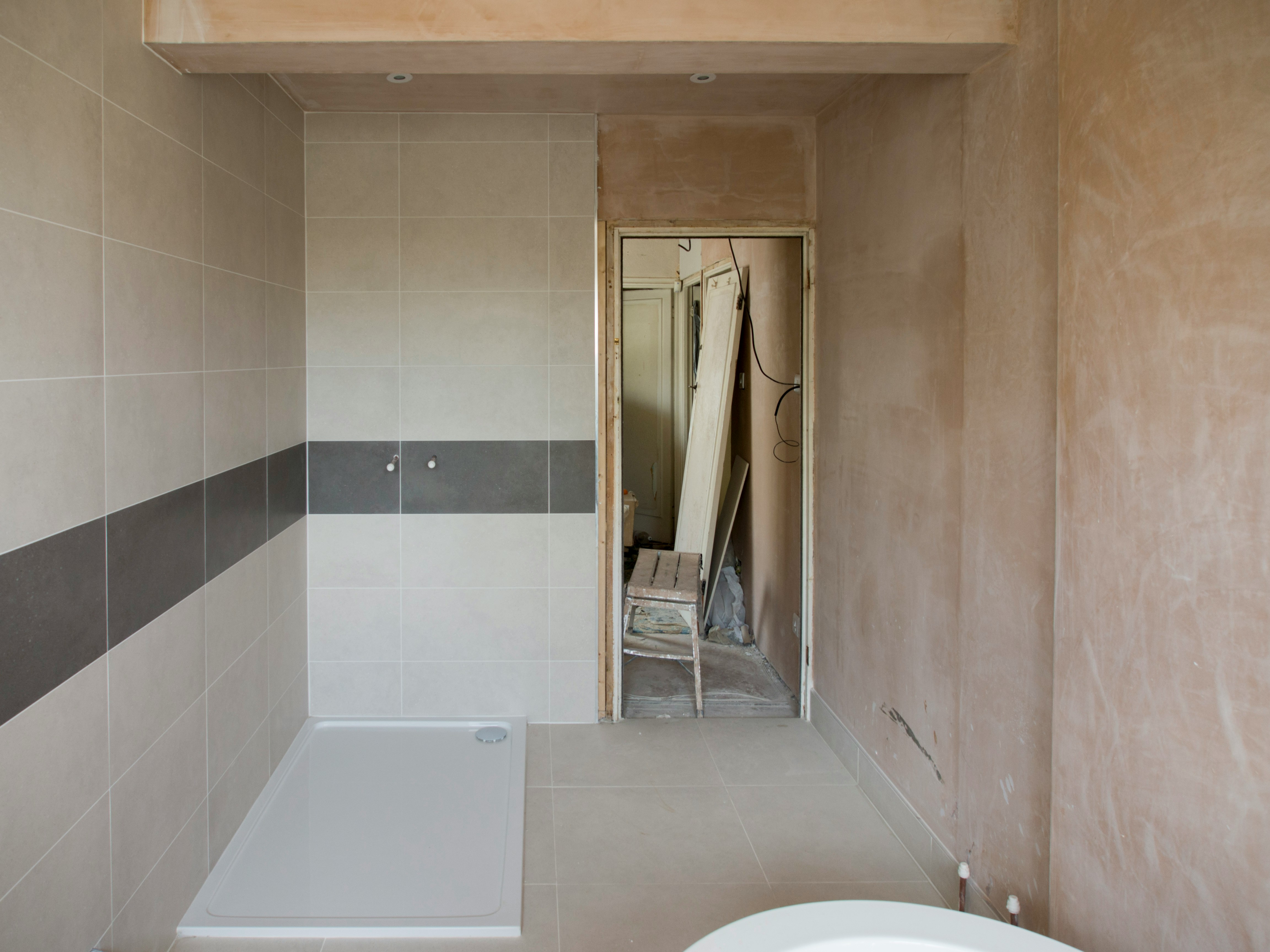 Before: stripped top-floor bathroom in Forest Hills with bare plaster and a new shower tray