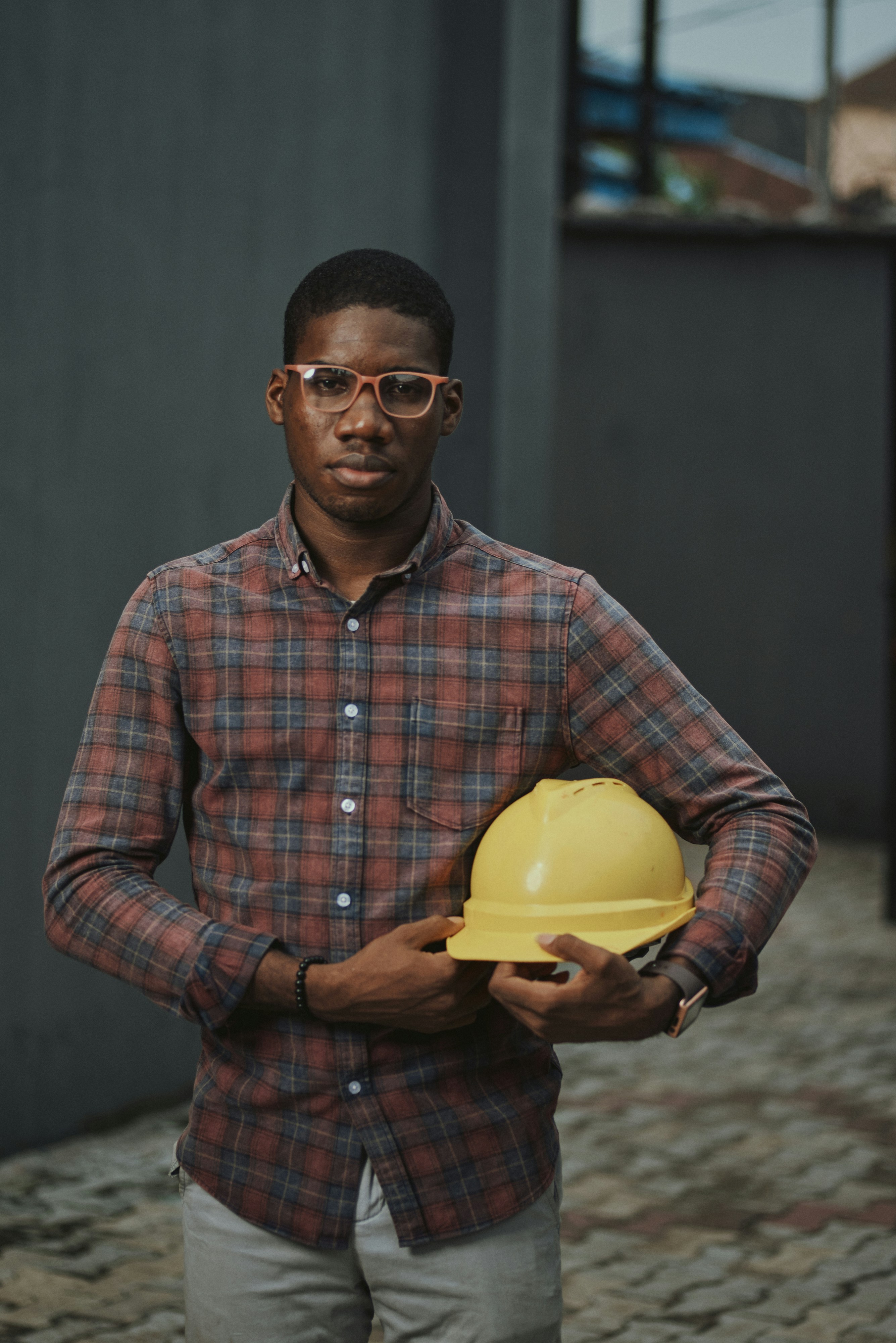 Jake Holloway, licensed electrician, holding a hard hat on site