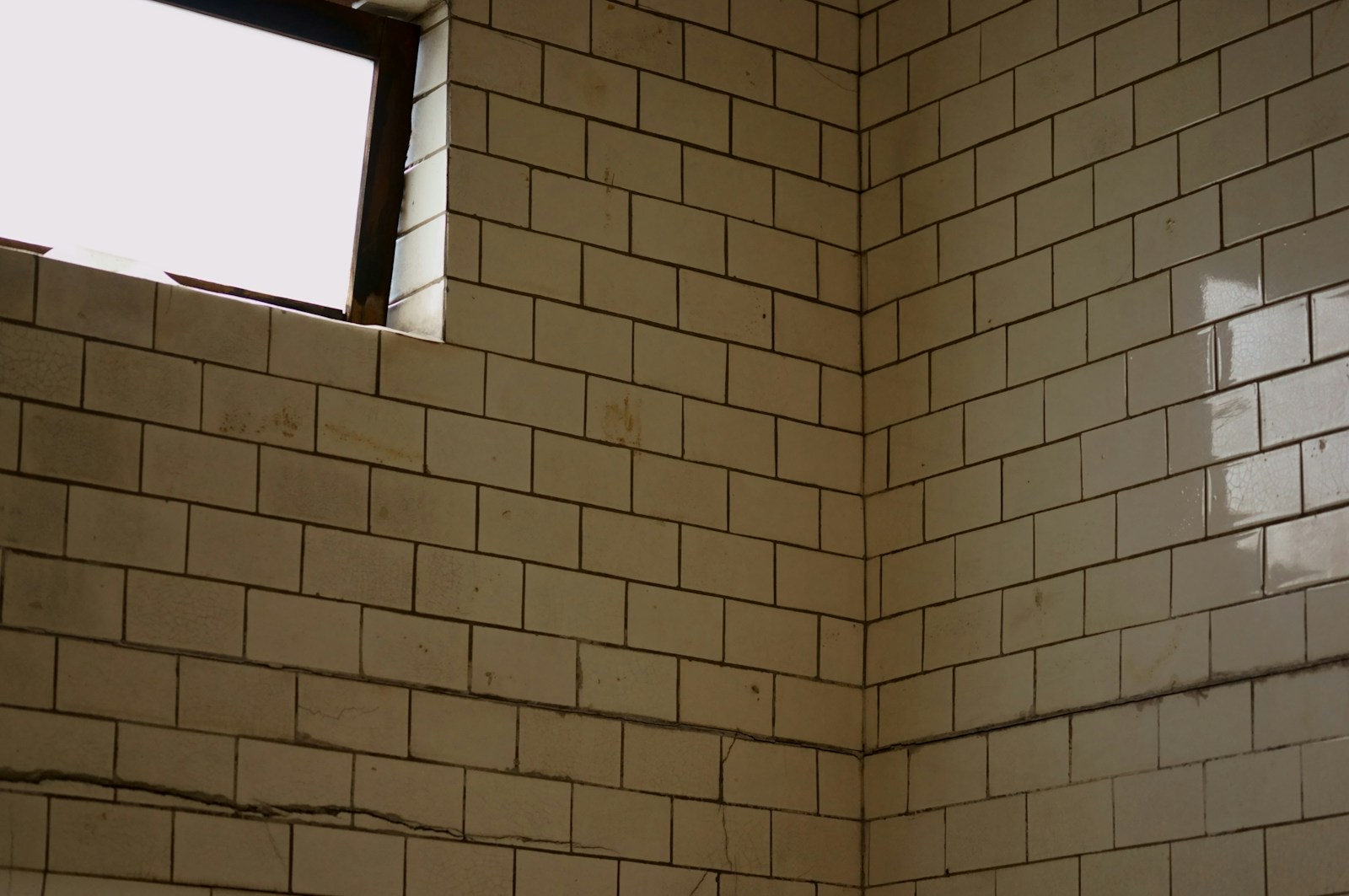 White subway tile being installed on a bathroom wall