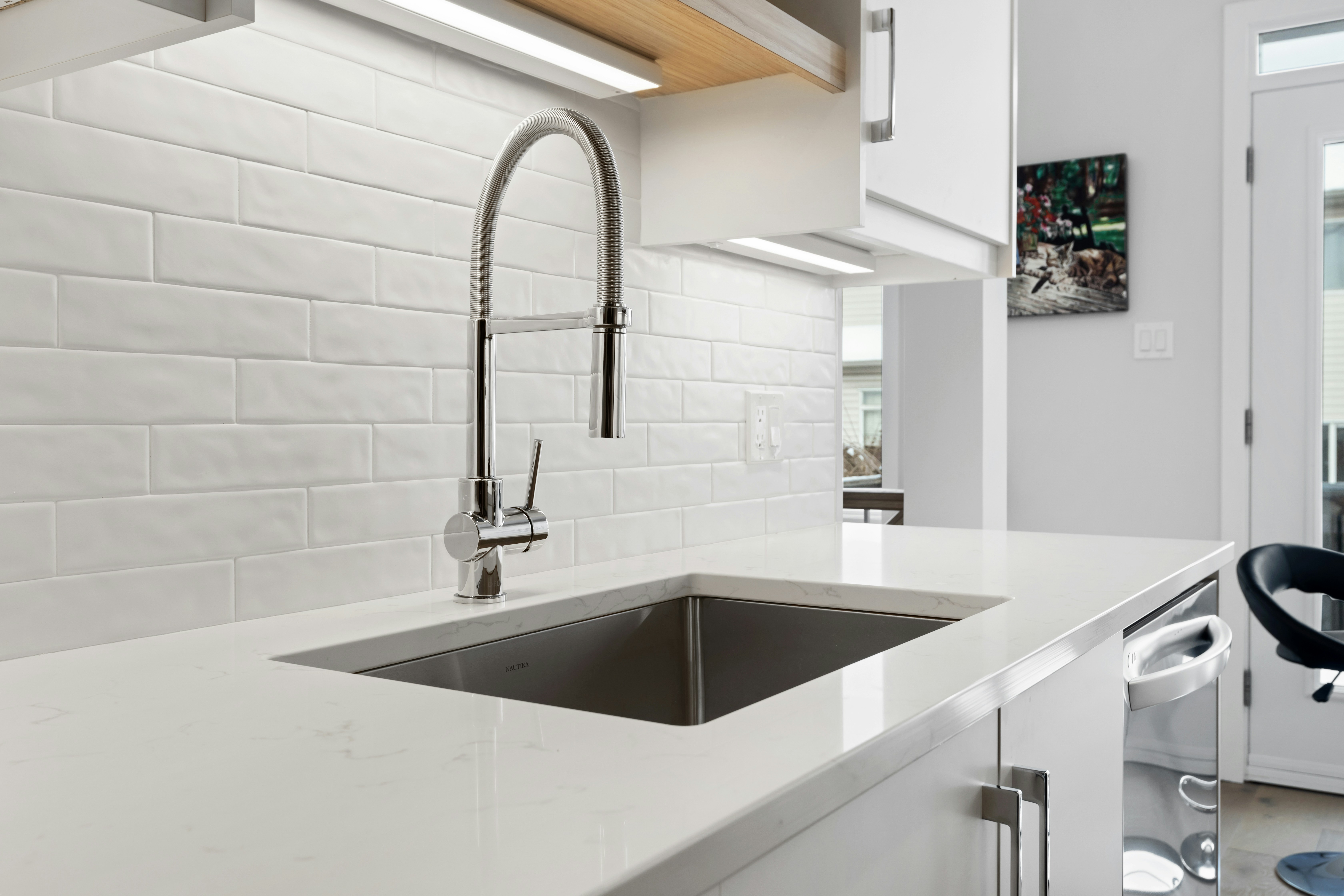 After: new undermount sink, pull-down faucet and tiled backsplash in the finished kitchen